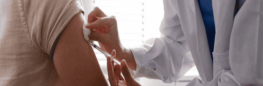 Médico aplica vacuna a paciente
